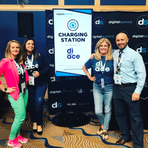 Diace Designs Team at Digital Summit 2018 | Jessica, Karissa, and Lori in front of charing station